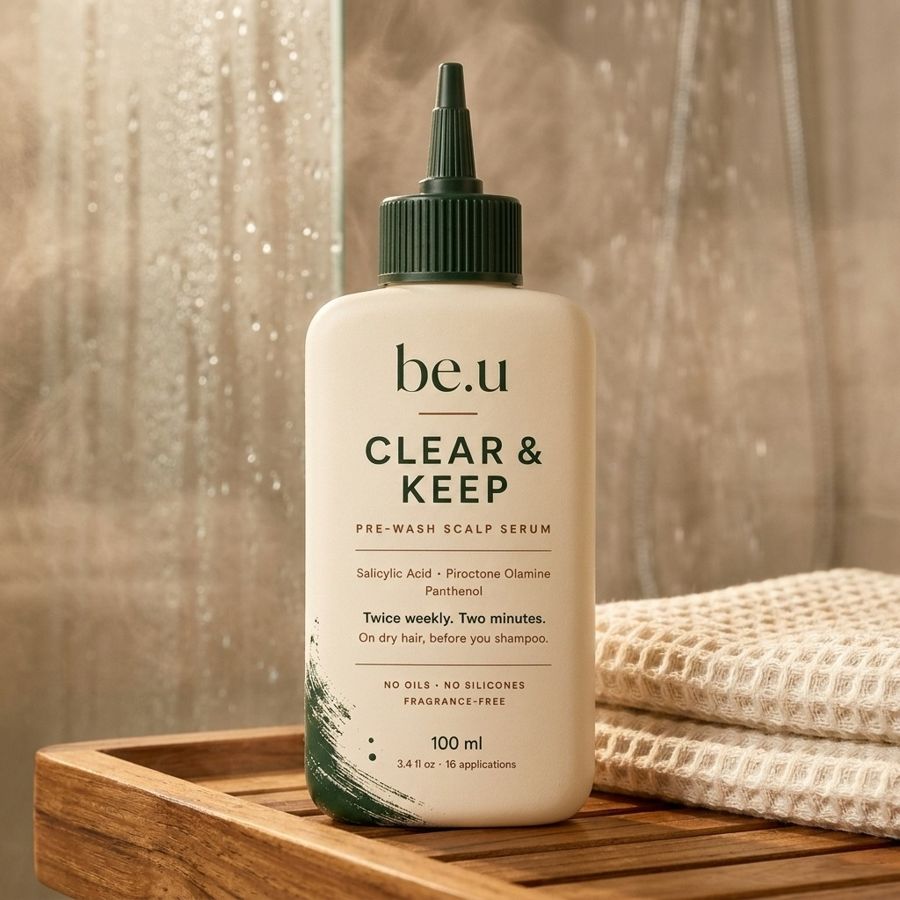 The bottle on a teak tray beside a steamed shower screen